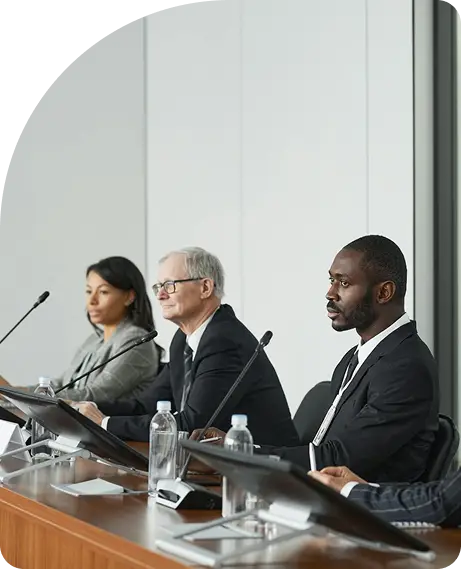 A diverse group of business professionals participate in a conference panel discussion, emphasizing the importance of joining CYBORIUM's cybersecurity provider network.