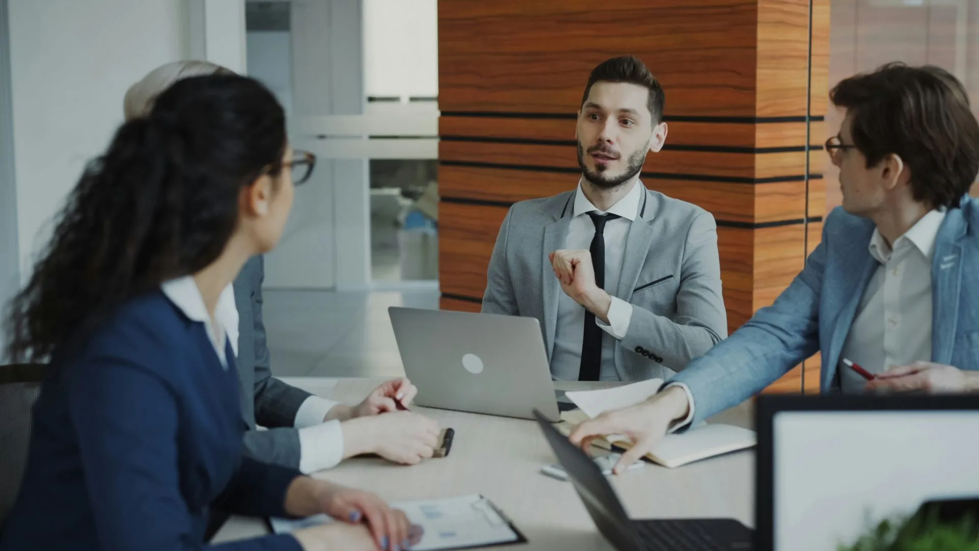 Enterprise team discussing procurement advisory options around a meeting table