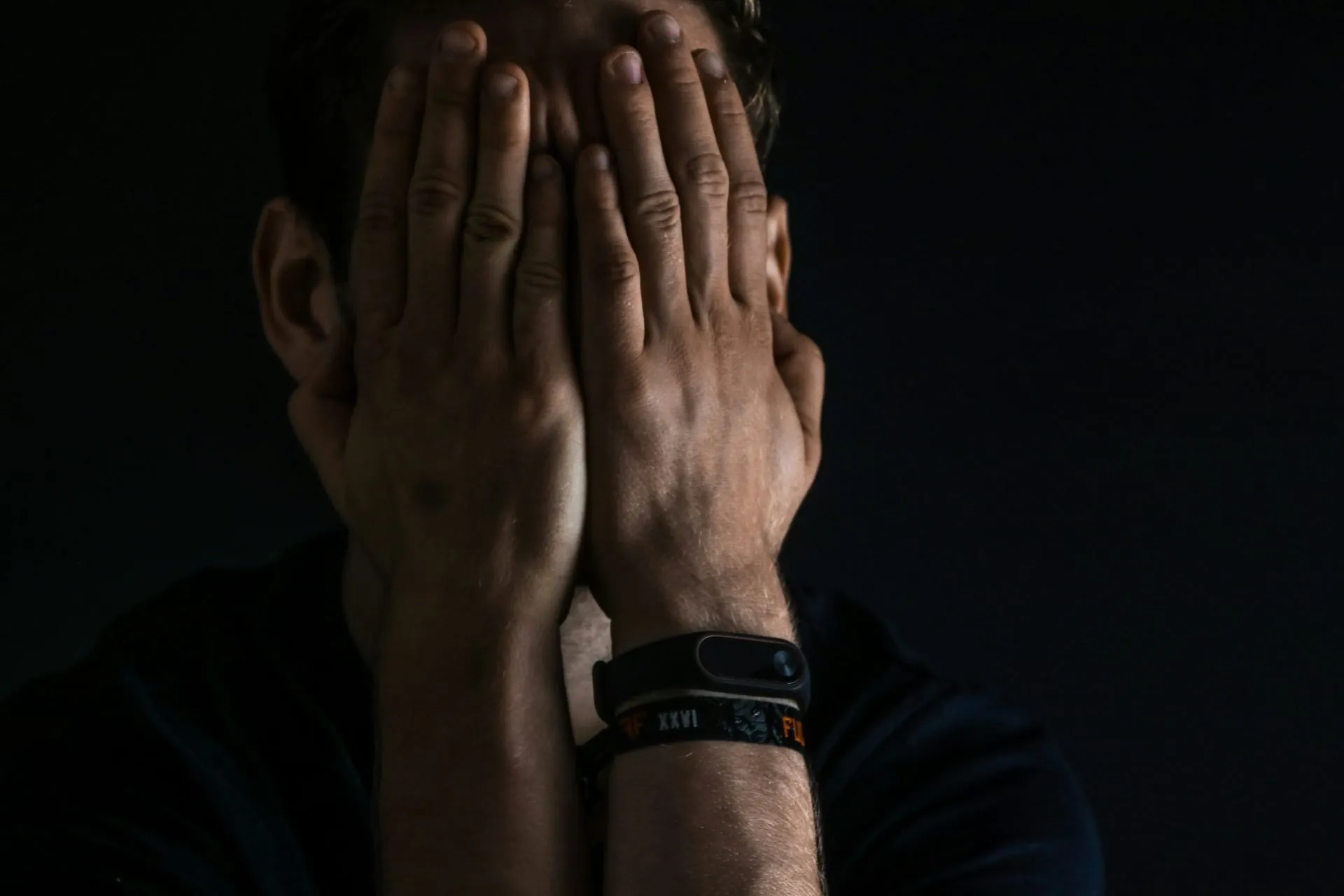Distressed professional covering his face with both hands